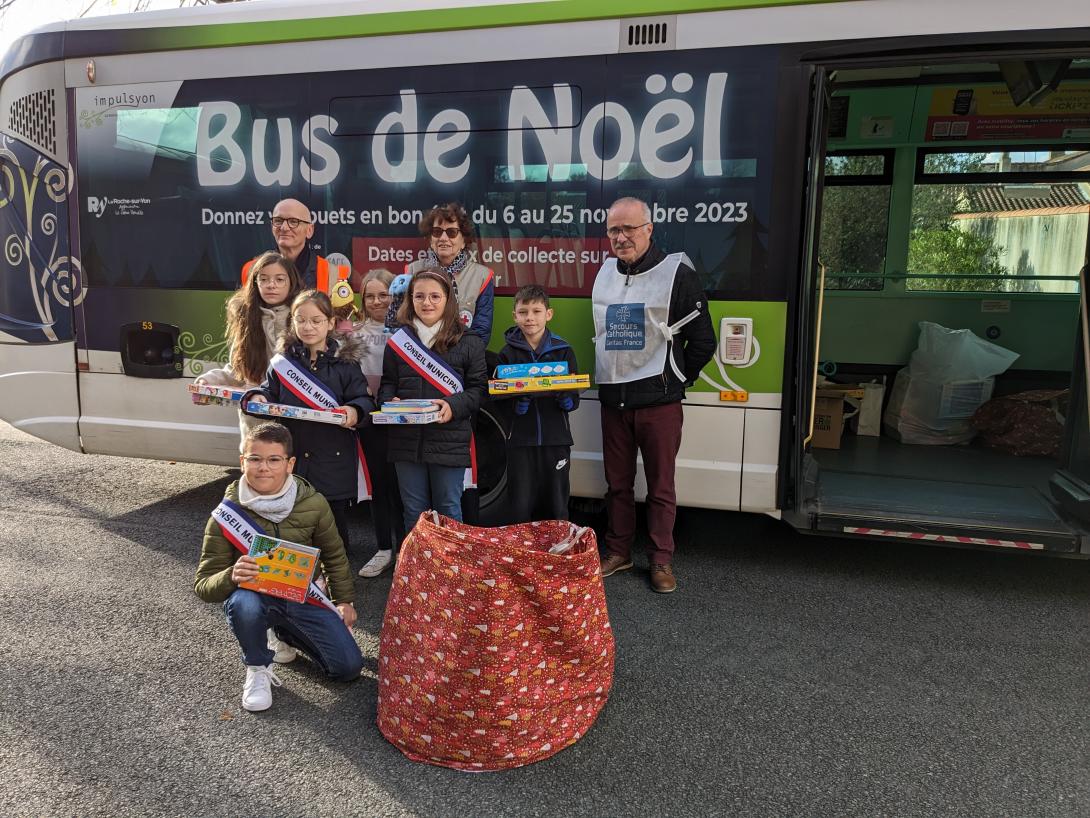 Les enfants distribuant des cadeaux pour le Bus de Noël 2023