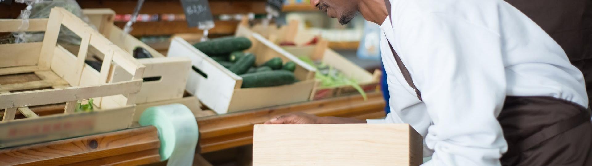 Homme en train de remettre de cageot en place dans un magasin