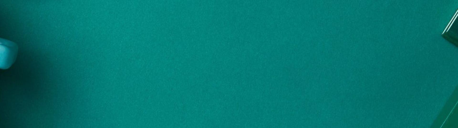 Bureau vert avec une tasse de café, un calepin et une plante