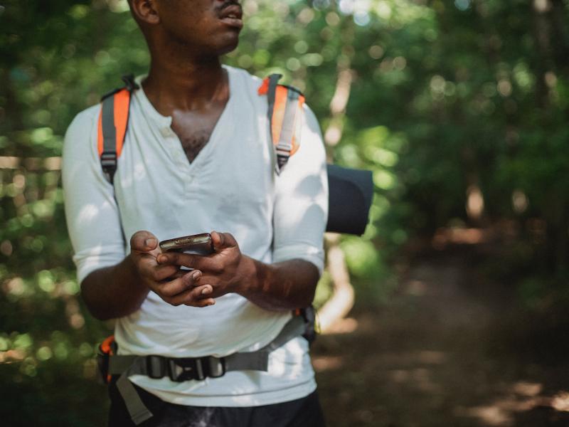 Un homme en randonnée avec son téléphone