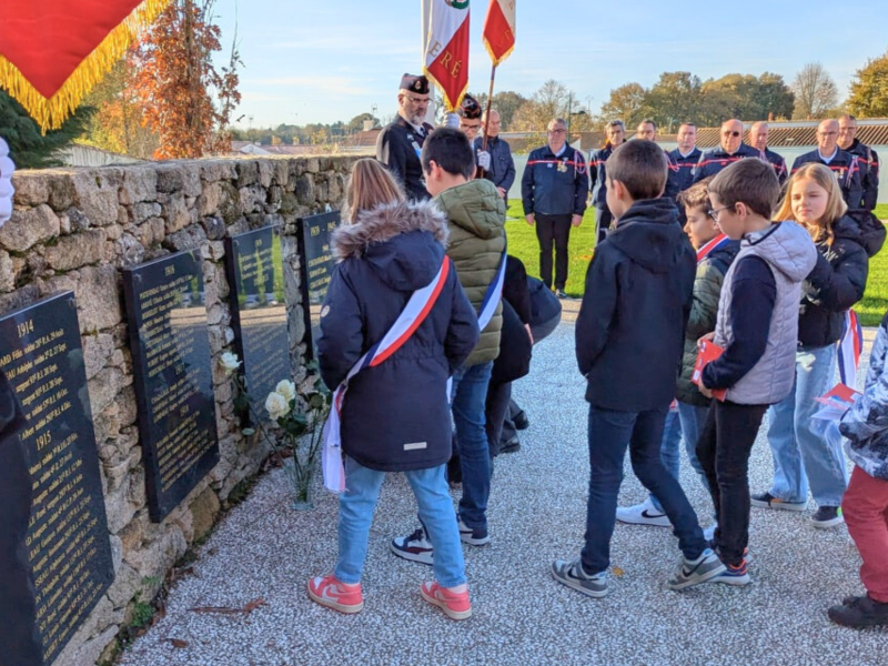 Les CME et d'autres élèves de CM2 devant le Monument aux Morts