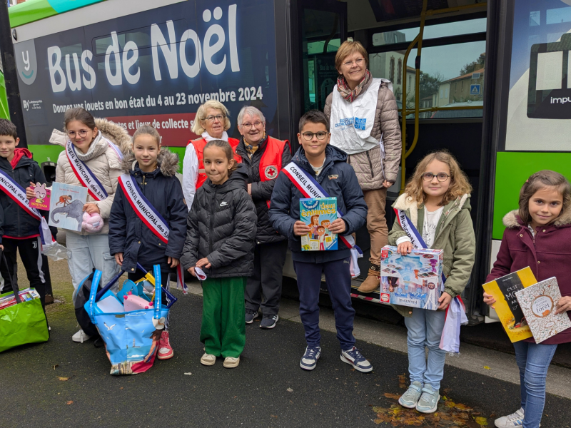 Les enfants remettent leurs cadeaux au Bus de Noël